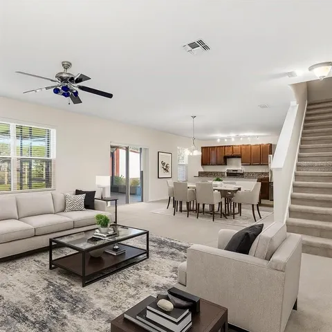 a living room with furniture ceiling fan and a window