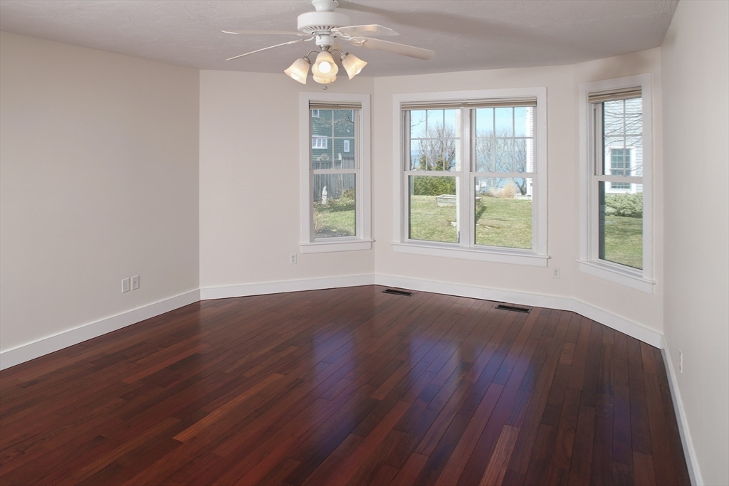9 Meade Avenue, Unit 1 Hull, MA 02045 - Photo 13 of 34 an empty room with wooden floor and windows