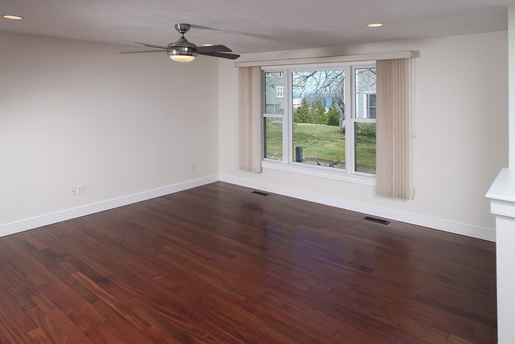 9 Meade Avenue, Unit 1 Hull, MA 02045 - Photo 16 of 34 a view of an empty room with wooden floor and a window