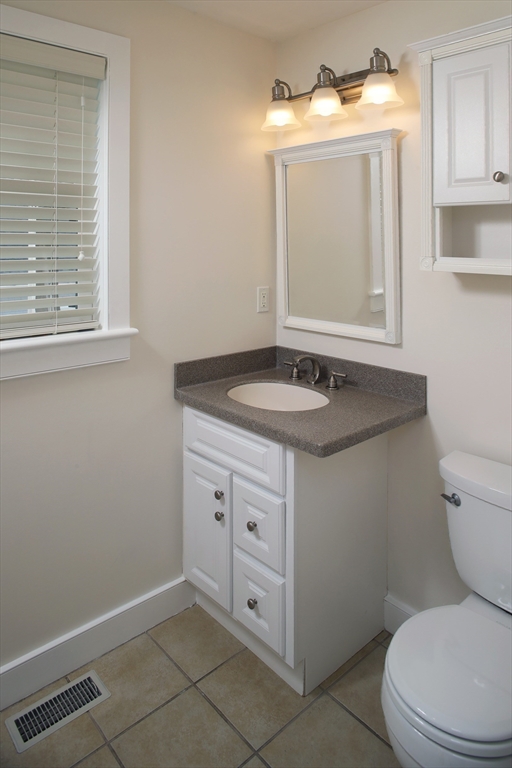 9 Meade Avenue, Unit 1 Hull, MA 02045 - Photo 25 of 34 a bathroom with a granite countertop toilet sink and mirror