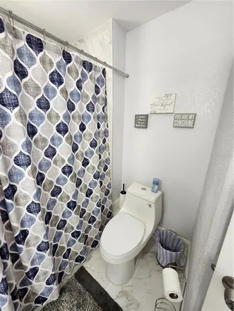 a white toilet sitting next to a shower curtain