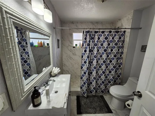a bathroom with a toilet and a shower curtain