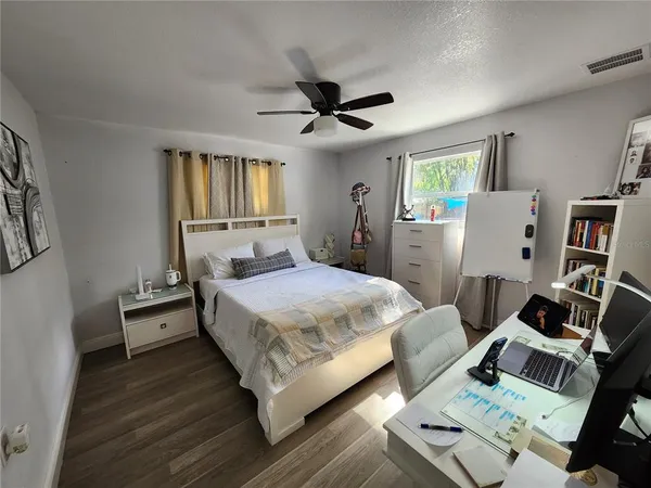 a bedroom with a bed and wooden floor