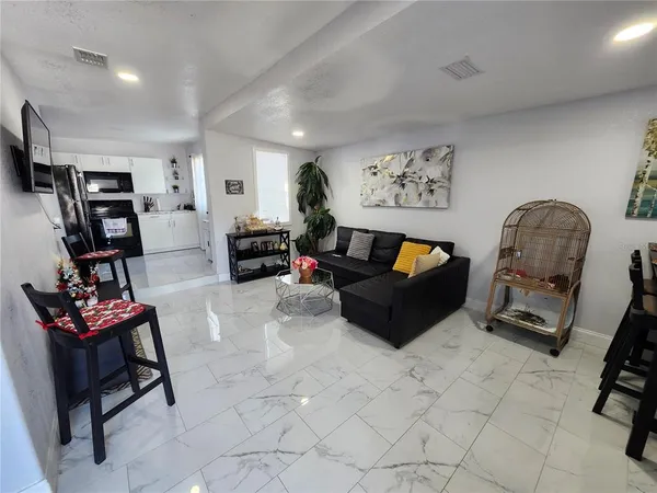 a living room with furniture a flat screen tv and gym equipment