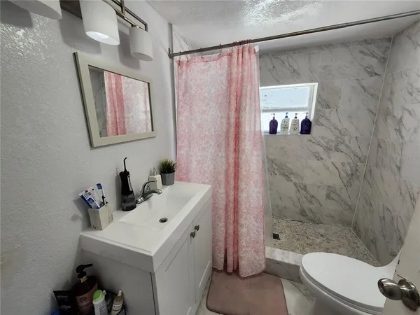 a bathroom with a sink toilet and shower