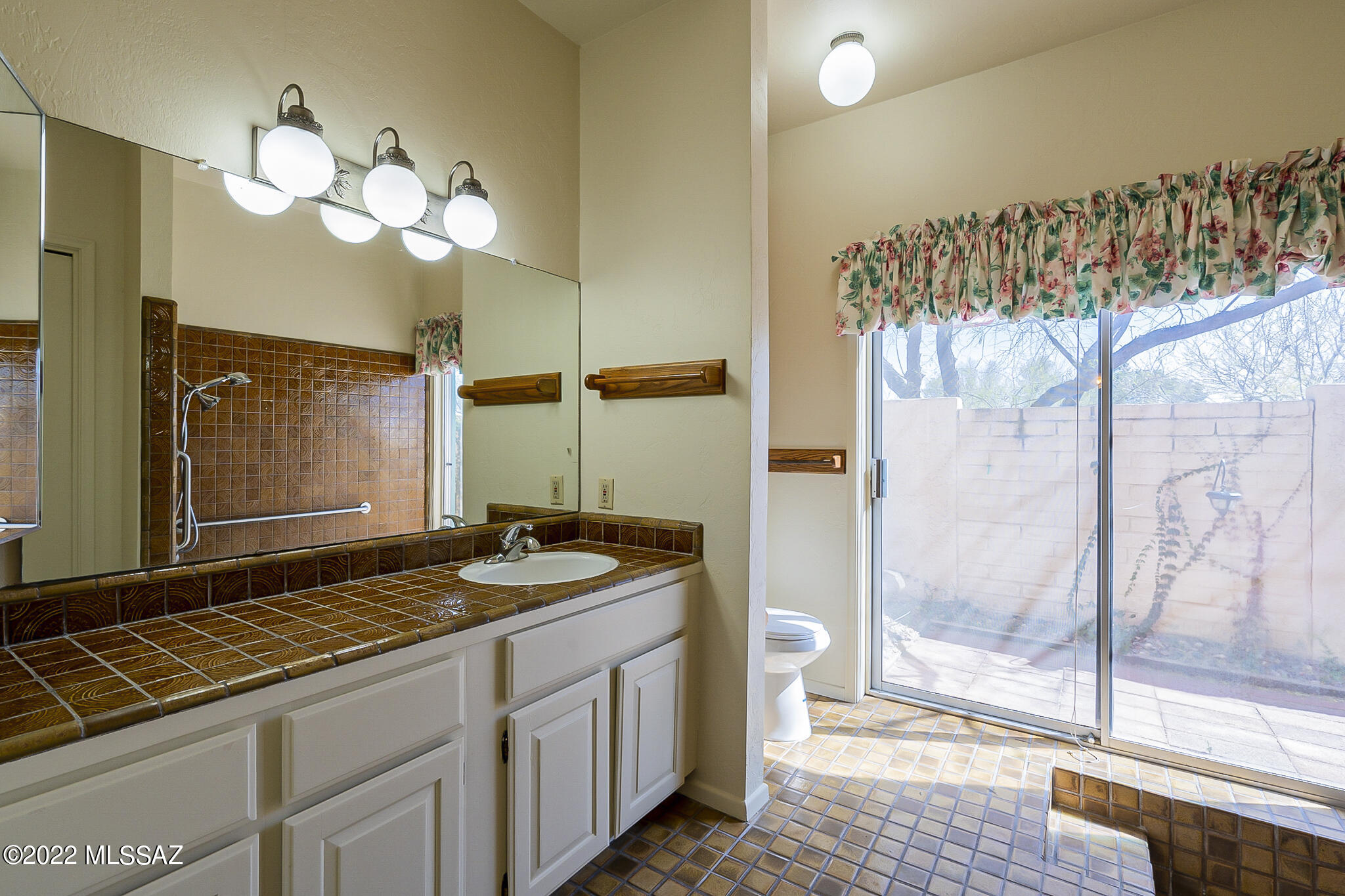8951 East Bears Path Road Tucson, AZ 85749 - Photo 23 of 41 a bathroom with a granite countertop sink a mirror and a shower