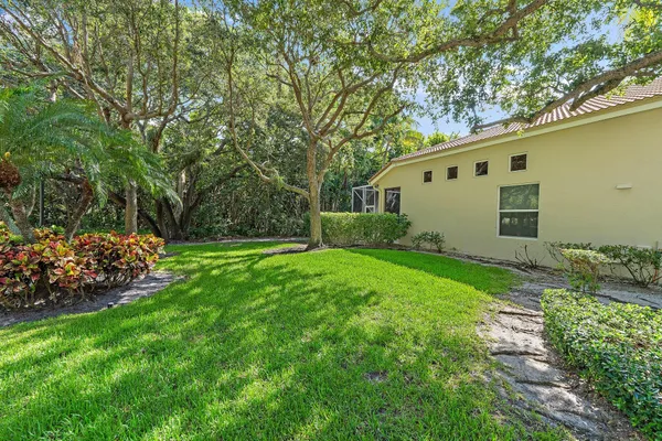 a front view of a house with a yard and potted plants
