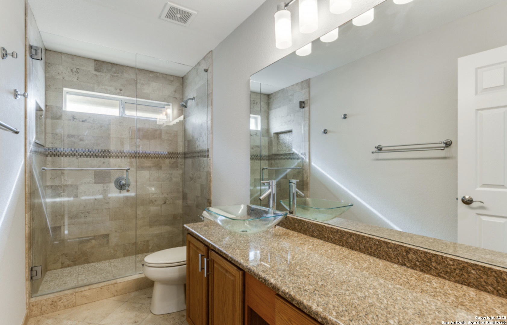 19431 Camino Ridge San Antonio, TX 78258 - Photo 11 of 25 a bathroom with a granite countertop sink a toilet and shower