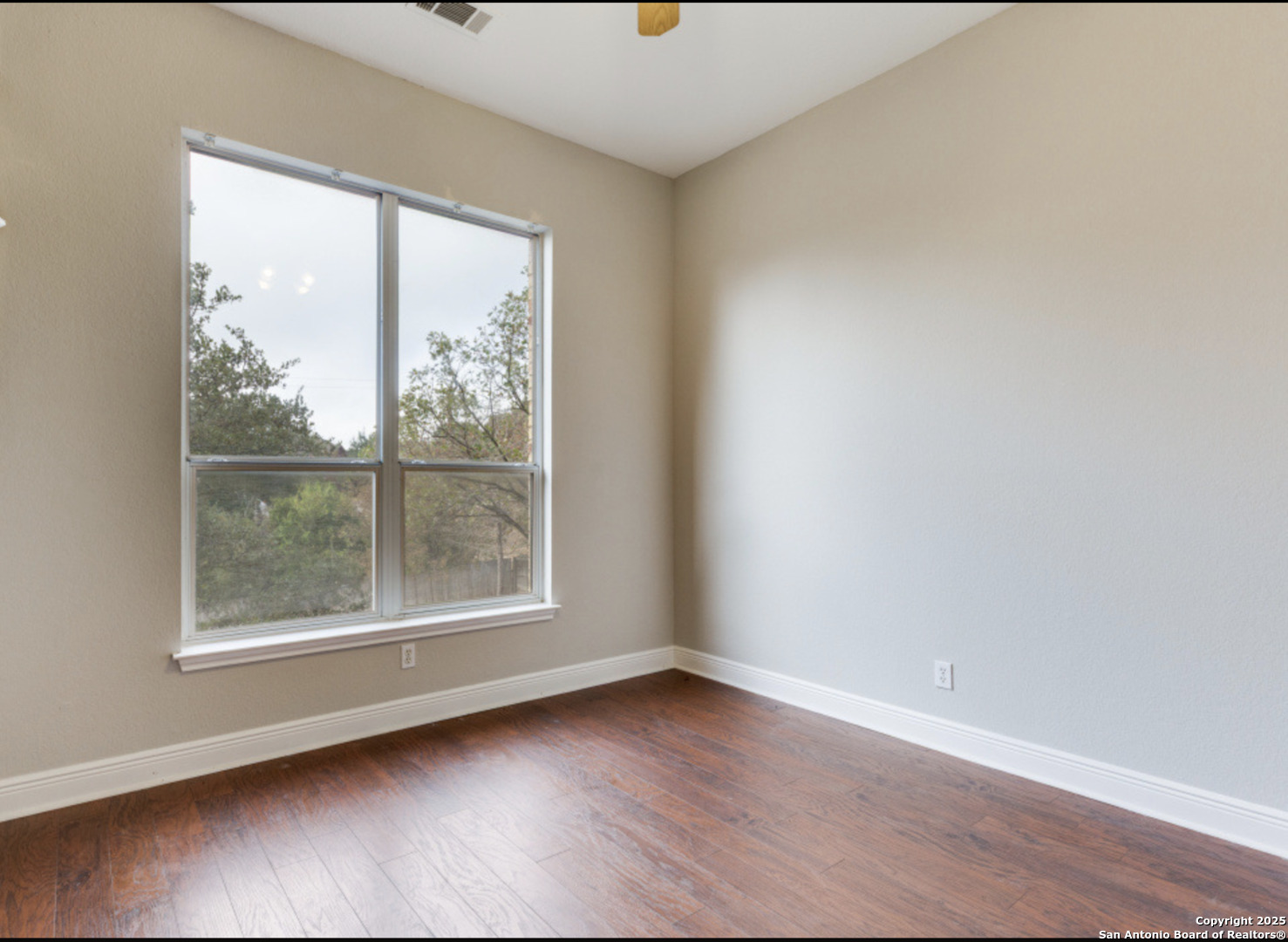 19431 Camino Ridge San Antonio, TX 78258 - Photo 13 of 25 an empty room with wooden floor and windows
