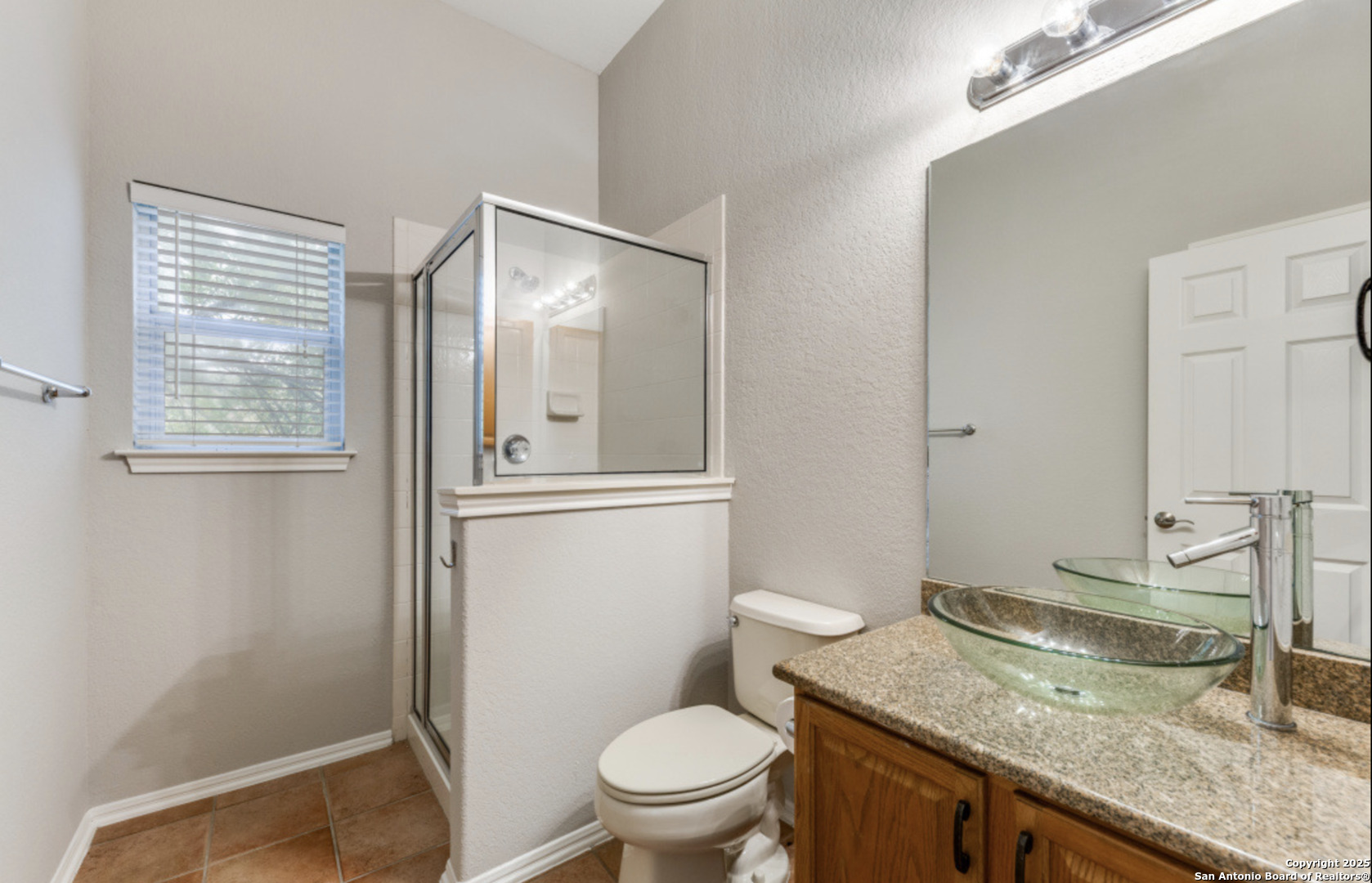 19431 Camino Ridge San Antonio, TX 78258 - Photo 14 of 25 a bathroom with a granite countertop sink mirror vanity and toilet