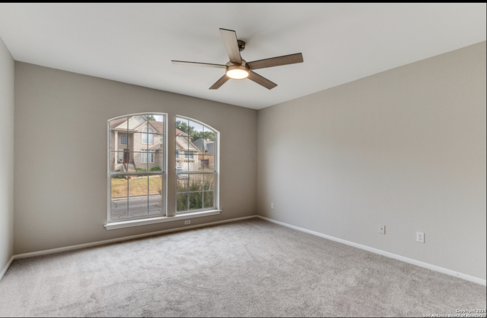 19431 Camino Ridge San Antonio, TX 78258 - Photo 10 of 25 an empty room with windows and ceiling fan