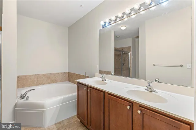 a bathroom with a tub a sink and mirror