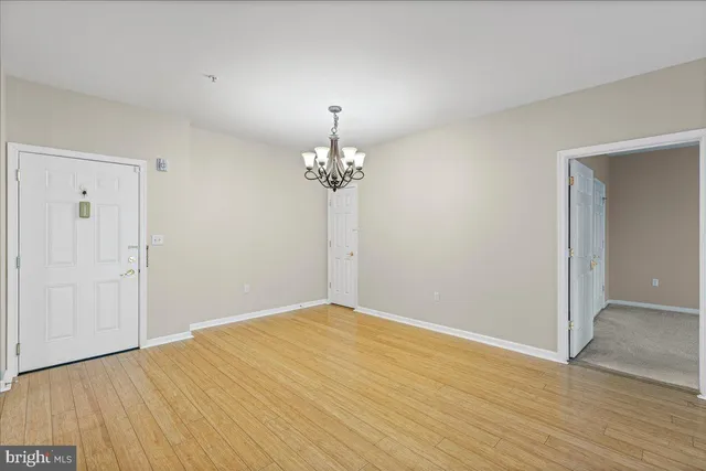 a view of a room with wooden floor chandelier and closet