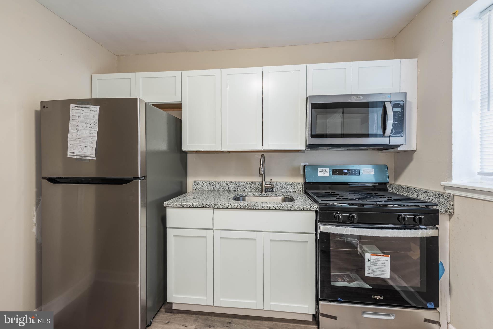 1737 North Dallas Street Baltimore, MD 21213 - Photo 4 of 14 a kitchen with a stove microwave and refrigerator