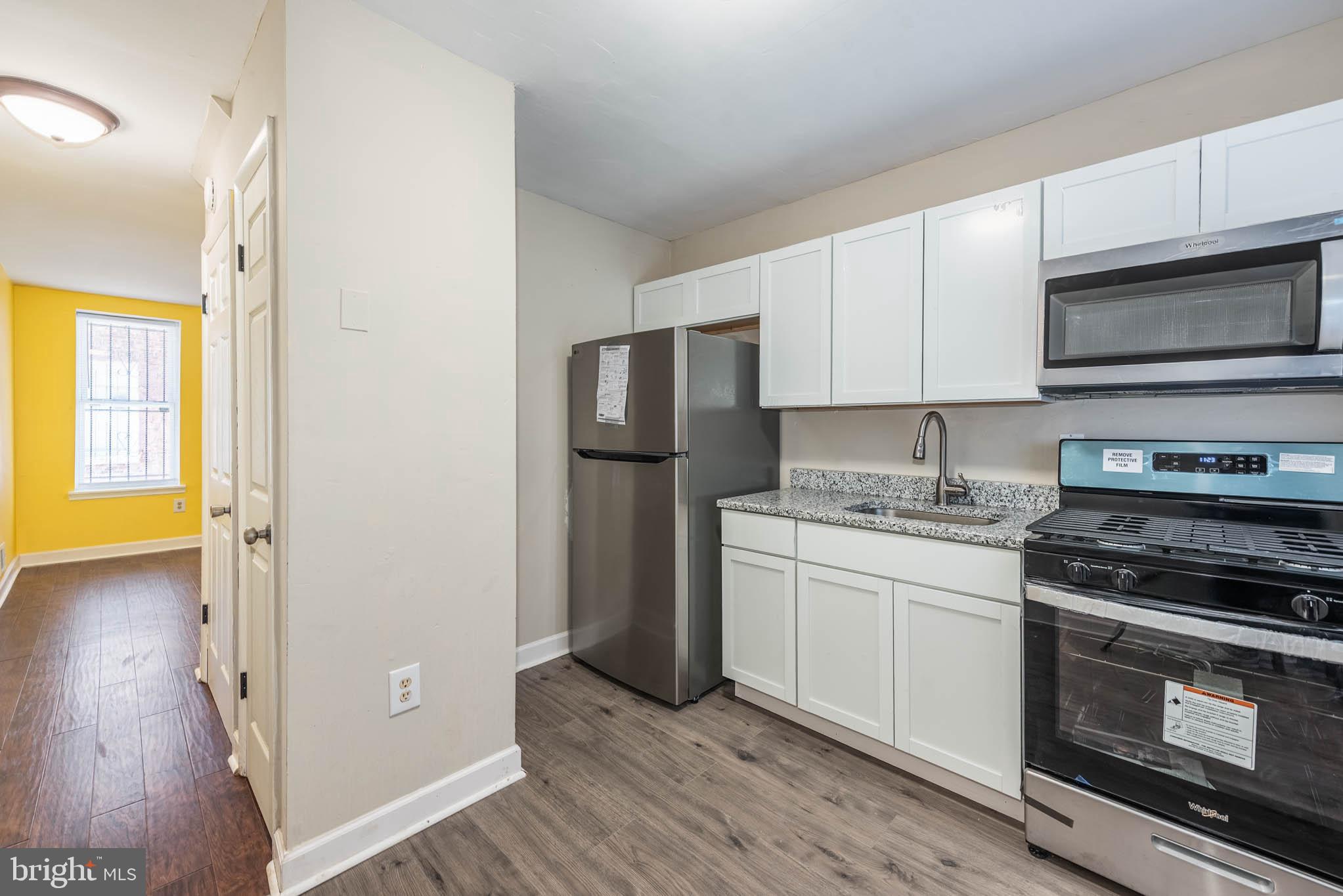 1737 North Dallas Street Baltimore, MD 21213 - Photo 5 of 14 a kitchen with stainless steel appliances granite countertop a refrigerator stove and sink