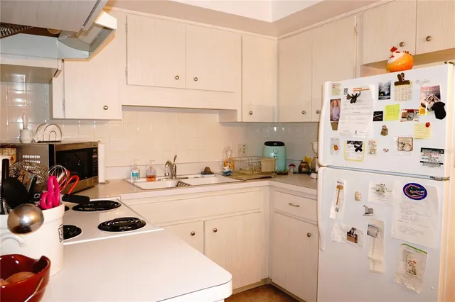 a kitchen with white cabinets and white appliances