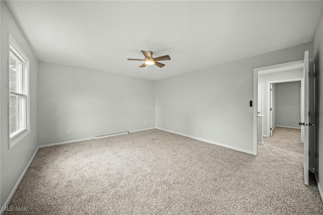 91 Paradise Road Painesville, OH 44077 - Photo 28 of 39 Carpeted empty room featuring a baseboard radiator and a ceiling fan