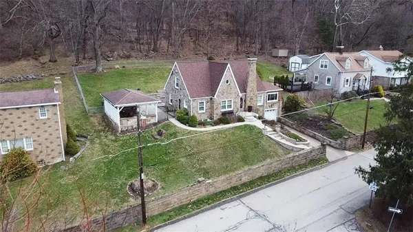 an aerial view of residential houses with outdoor space and parking