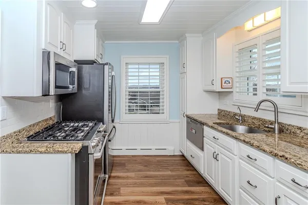 a kitchen with granite countertop wooden cabinets and a stove top oven