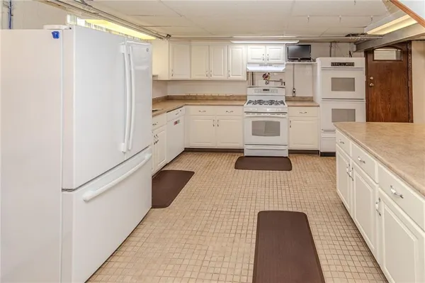 a kitchen with a white cabinets and white appliances