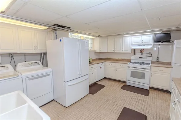 a kitchen with stainless steel appliances white cabinets and wooden floor