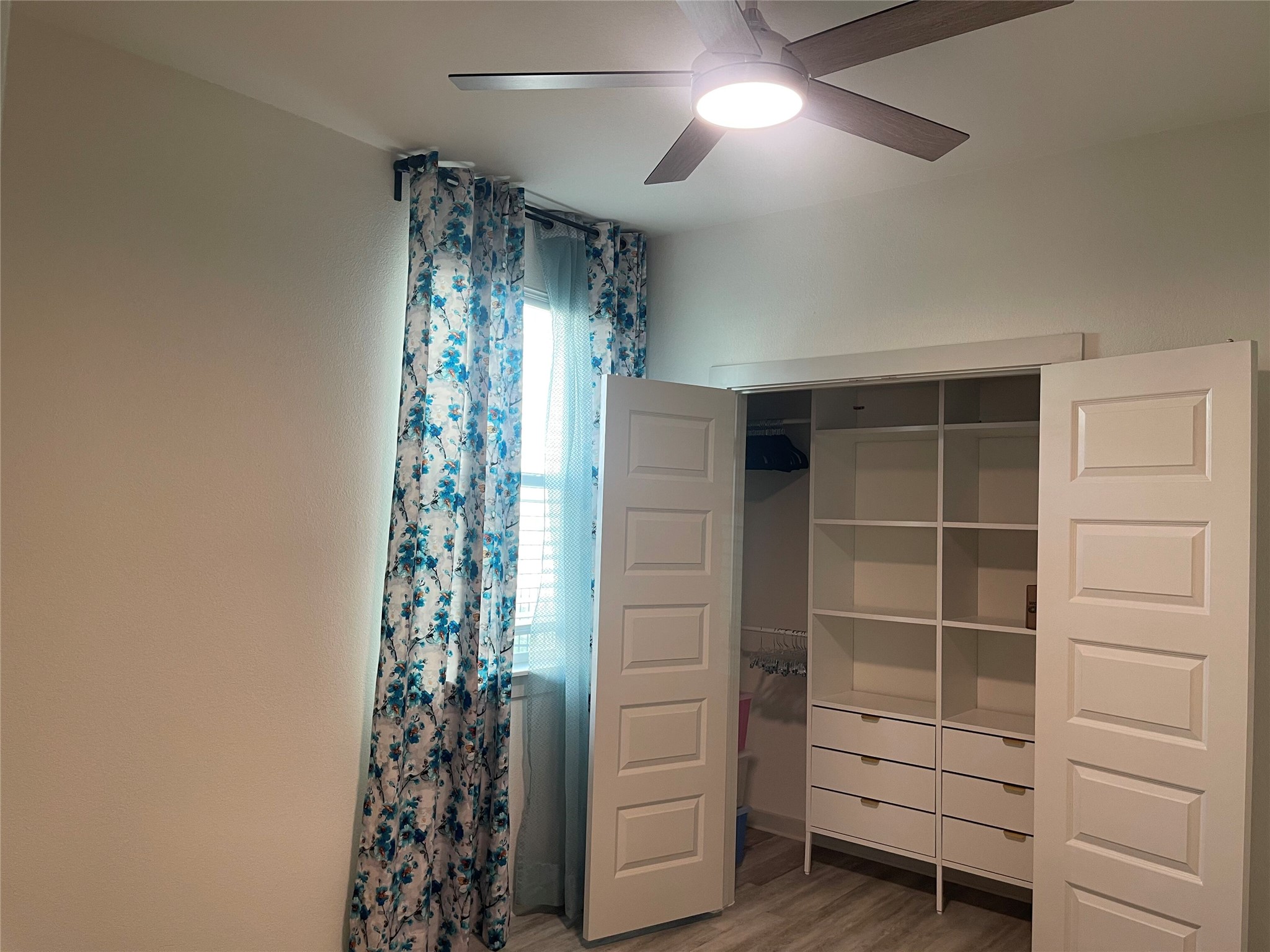 145 Merrick Road Georgetown, TX 78628 - Photo 24 of 32 A spacious closet system offers built-in shelving and drawers beneath wood-look flooring.