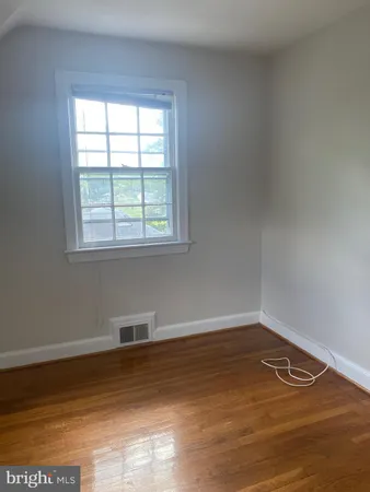 a view of a room with wooden floor and a window