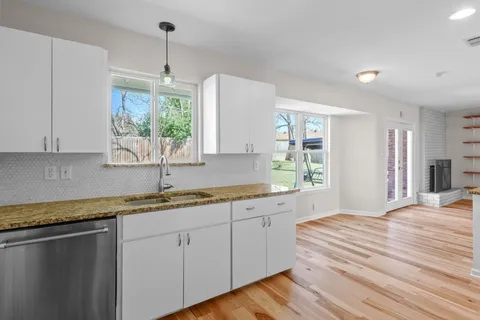 a kitchen with a sink window and cabinets
