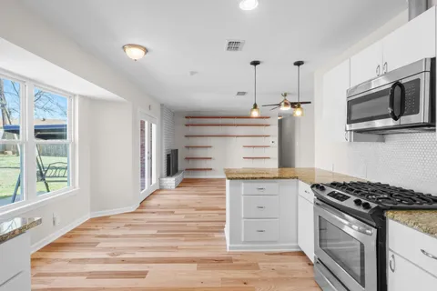 a kitchen with stainless steel appliances granite countertop a stove and a microwave