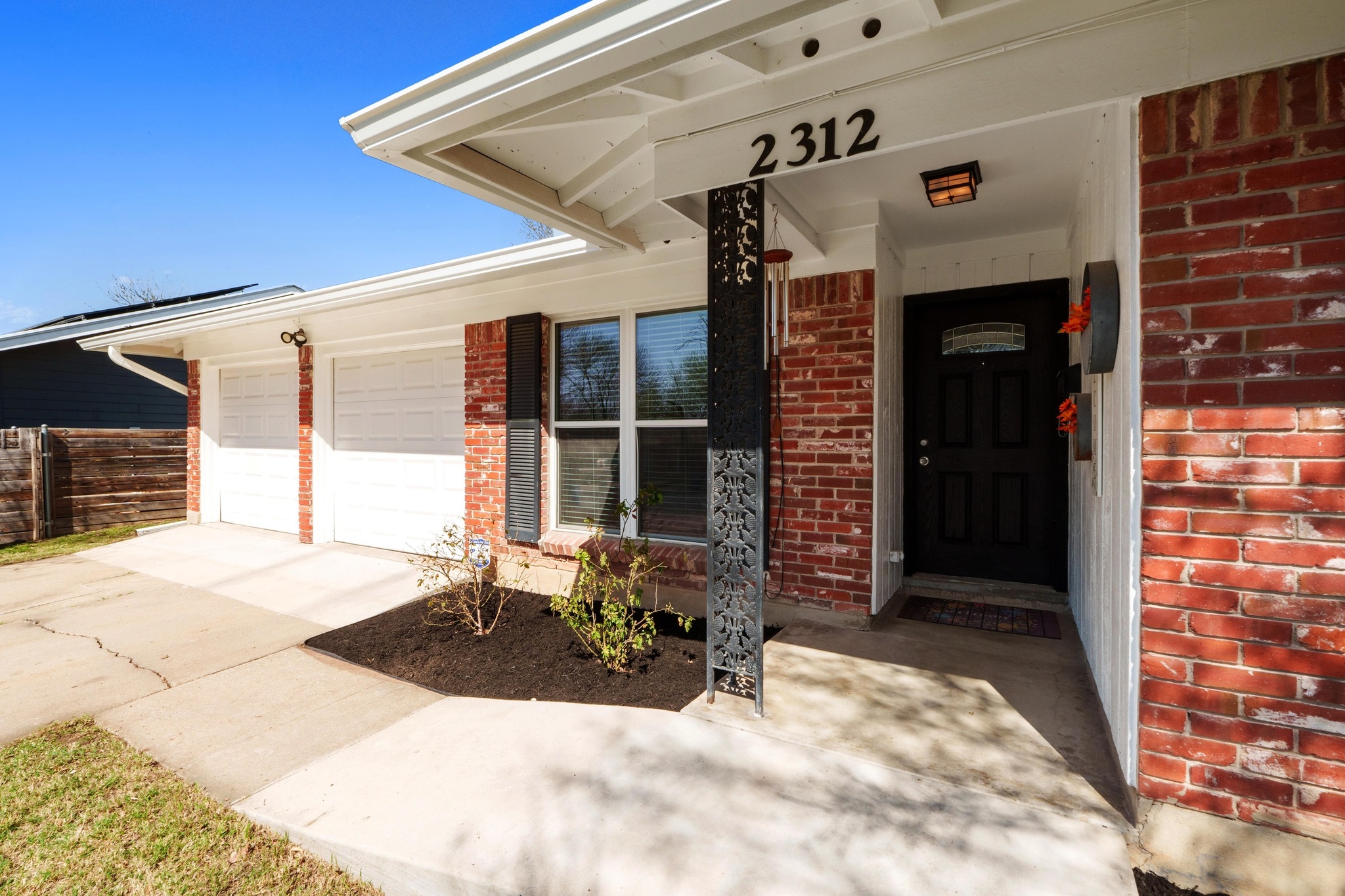 2312 Rogge Lane Austin, TX 78723 - Photo 2 of 34 Entrance to property with brick siding, a garage, and driveway