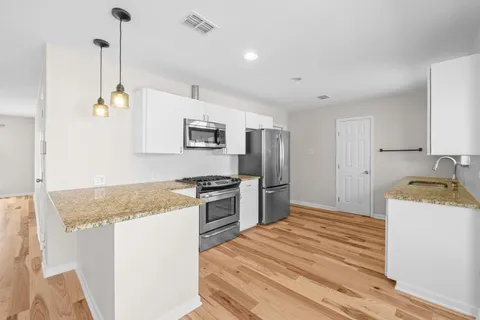 a kitchen with granite countertop a sink stove and refrigerator