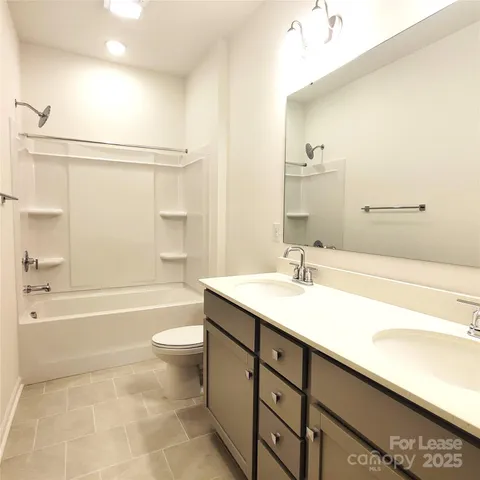 a bathroom with a granite countertop sink a toilet and bathtub