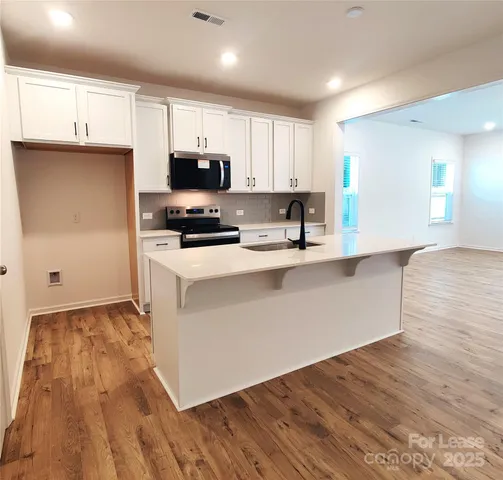 a kitchen with stainless steel appliances a refrigerator sink and microwave