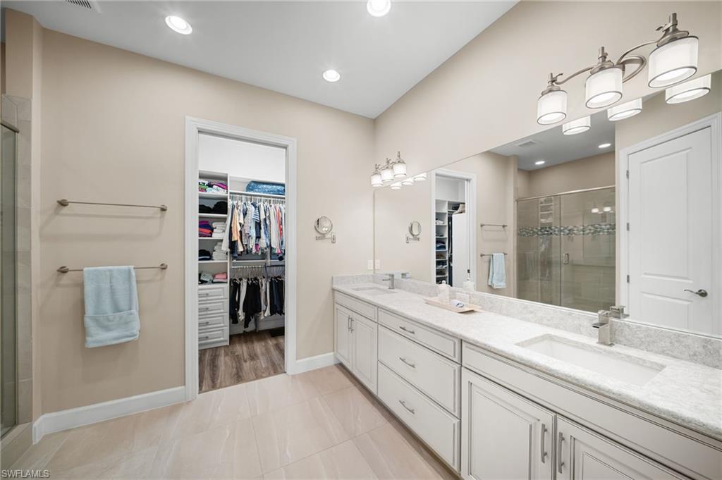 9672 Montelanico Loop, Unit 203 Naples, FL 34119 - Photo 17 of 49 a spacious bathroom with a double vanity sink mirror and double