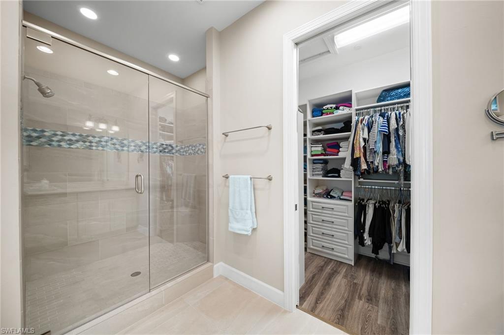 9672 Montelanico Loop, Unit 203 Naples, FL 34119 - Photo 18 of 49 a view of walk in closet with clothes