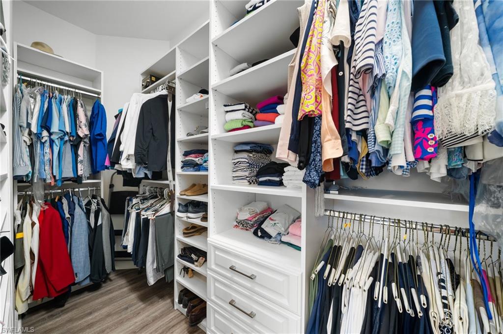 9672 Montelanico Loop, Unit 203 Naples, FL 34119 - Photo 19 of 49 a view of walk in closet with clothes and shoes