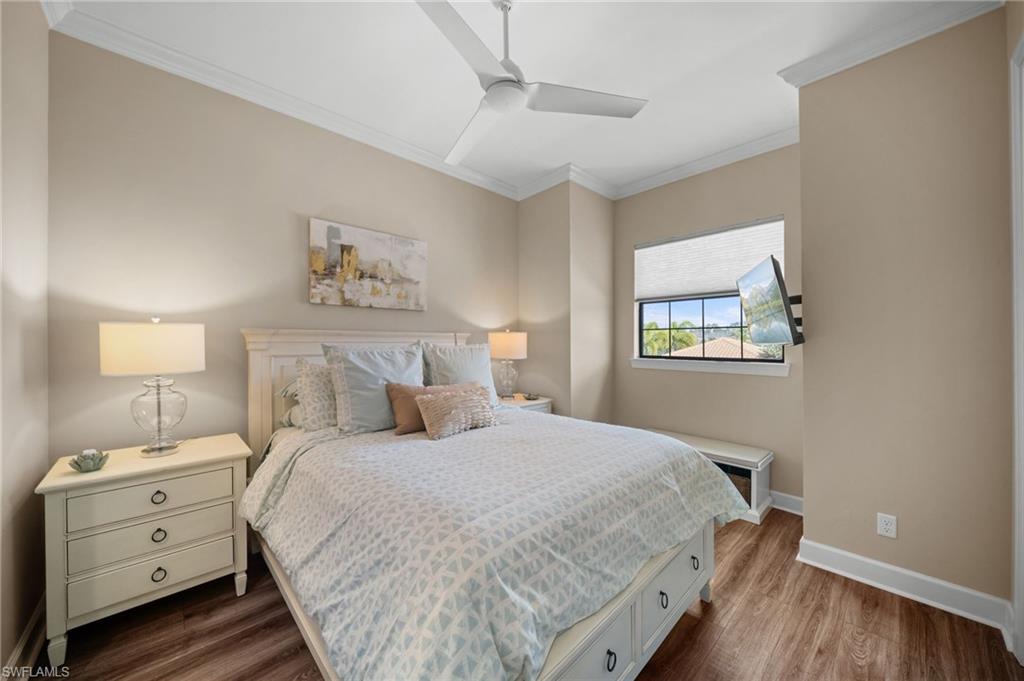 9672 Montelanico Loop, Unit 203 Naples, FL 34119 - Photo 20 of 49 a bedroom with a bed and a night stand