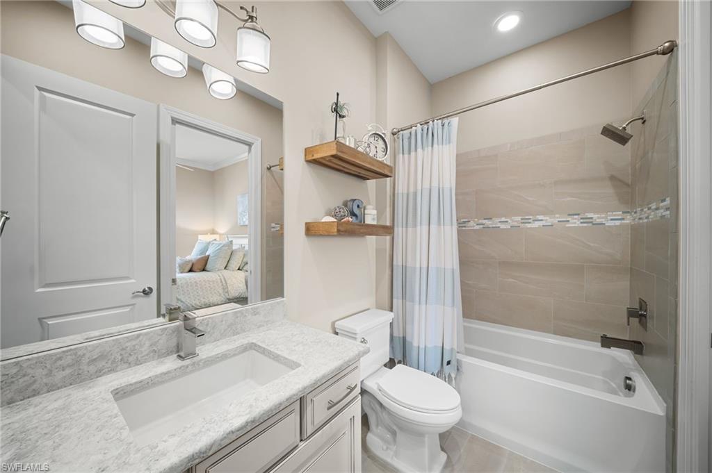 9672 Montelanico Loop, Unit 203 Naples, FL 34119 - Photo 21 of 49 a bathroom with a sink vanity granite toilet tub and shower