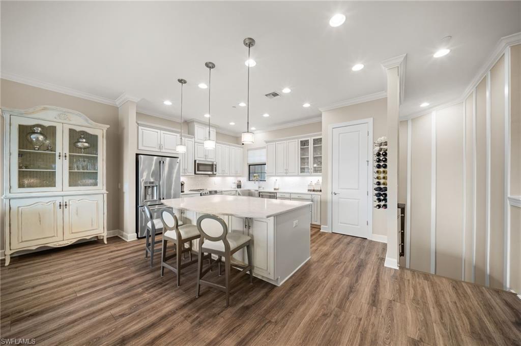 9672 Montelanico Loop, Unit 203 Naples, FL 34119 - Photo 9 of 49 a large kitchen with a table and chairs