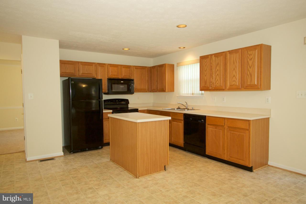 490 Copeland Road Fallston, MD 21047 - Photo 8 of 29 a kitchen with granite countertop a refrigerator and a stove top oven