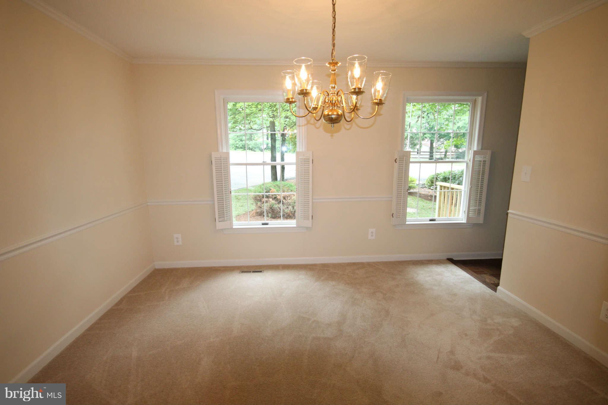 7510 Gambrill Road Springfield, VA 22153 - Photo 11 of 30 an empty room with windows and chandelier