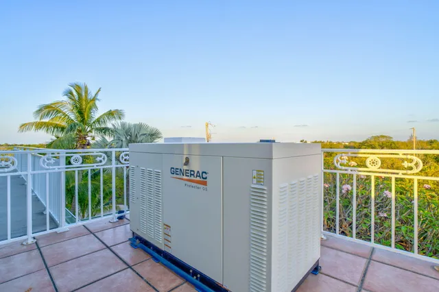 an aerial view of ocean and residential houses with outdoor space
