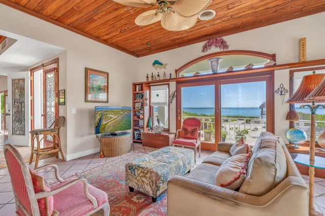 a view of a dining room with furniture a chandelier and large windows