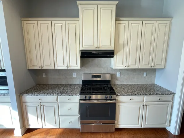 a metallic refrigerator freezer sitting inside of a kitchen