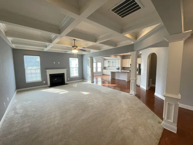 an empty room with windows and fireplace