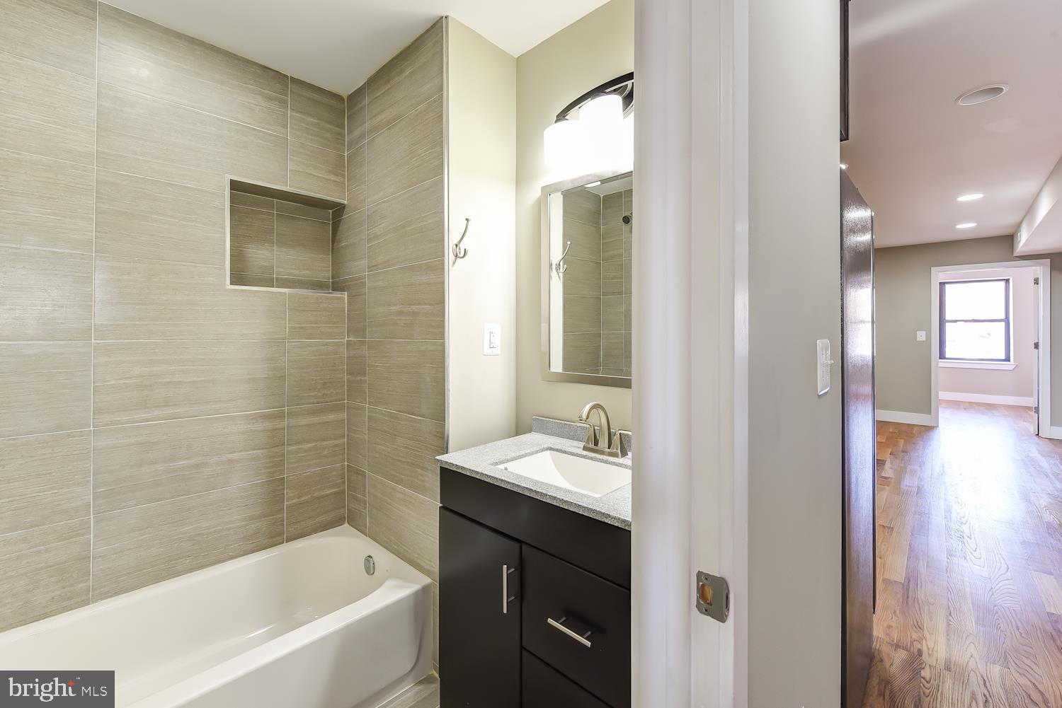 2031 Benning Road Northeast, Unit B Washington, DC 20002 - Photo 11 of 22 a bathroom with a bathtub sink and mirror