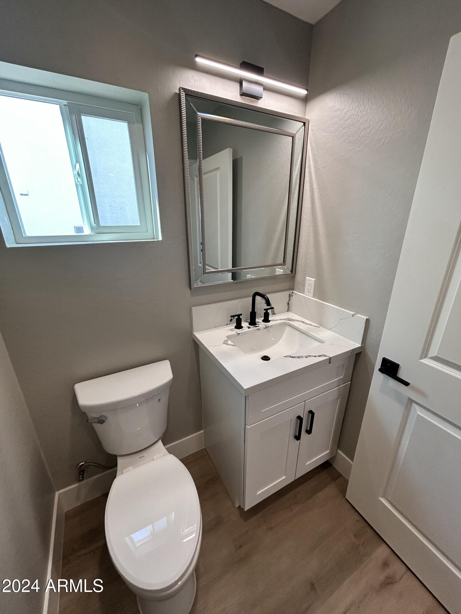 825 West Dobbins Road Phoenix, AZ 85041 - Photo 13 of 99 a bathroom with a toilet sink and mirror