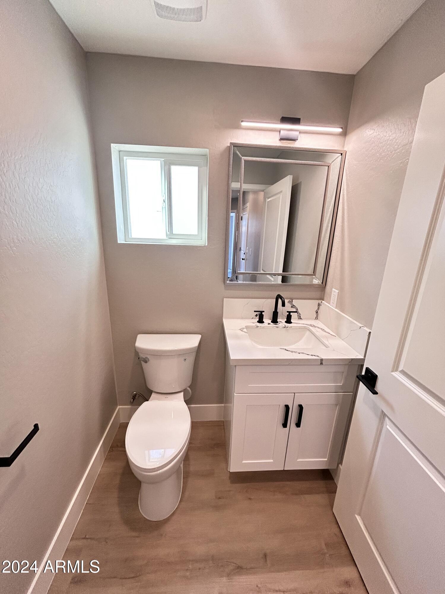 825 West Dobbins Road Phoenix, AZ 85041 - Photo 14 of 99 a bathroom with a toilet sink and mirror