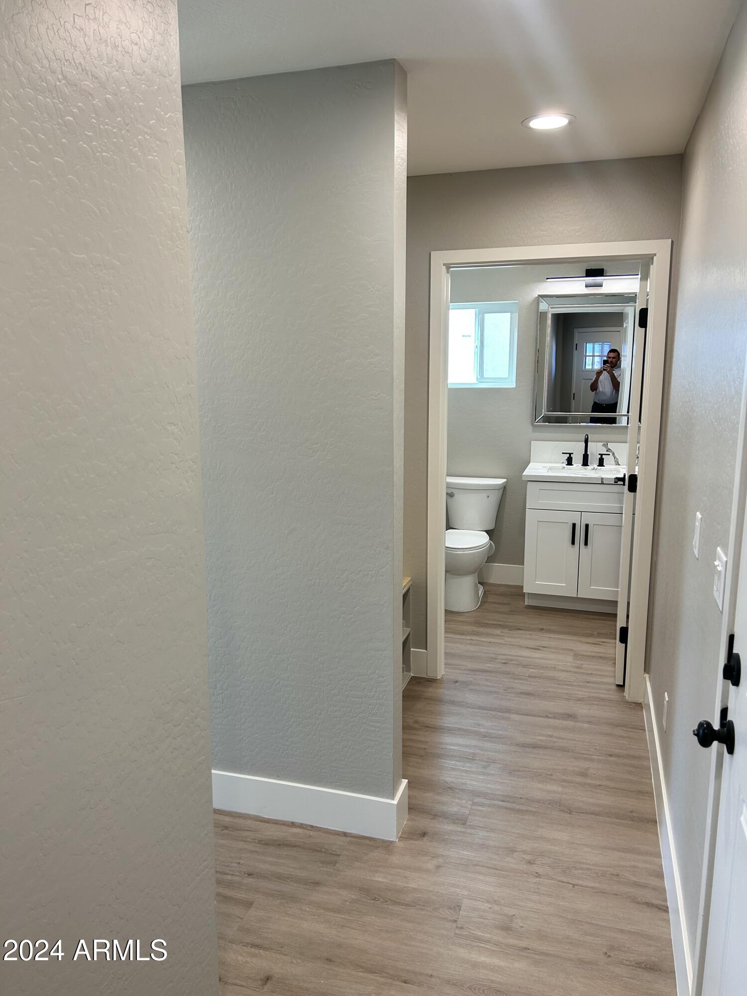 825 West Dobbins Road Phoenix, AZ 85041 - Photo 17 of 99 a view of a hallway with bathroom and wooden floor