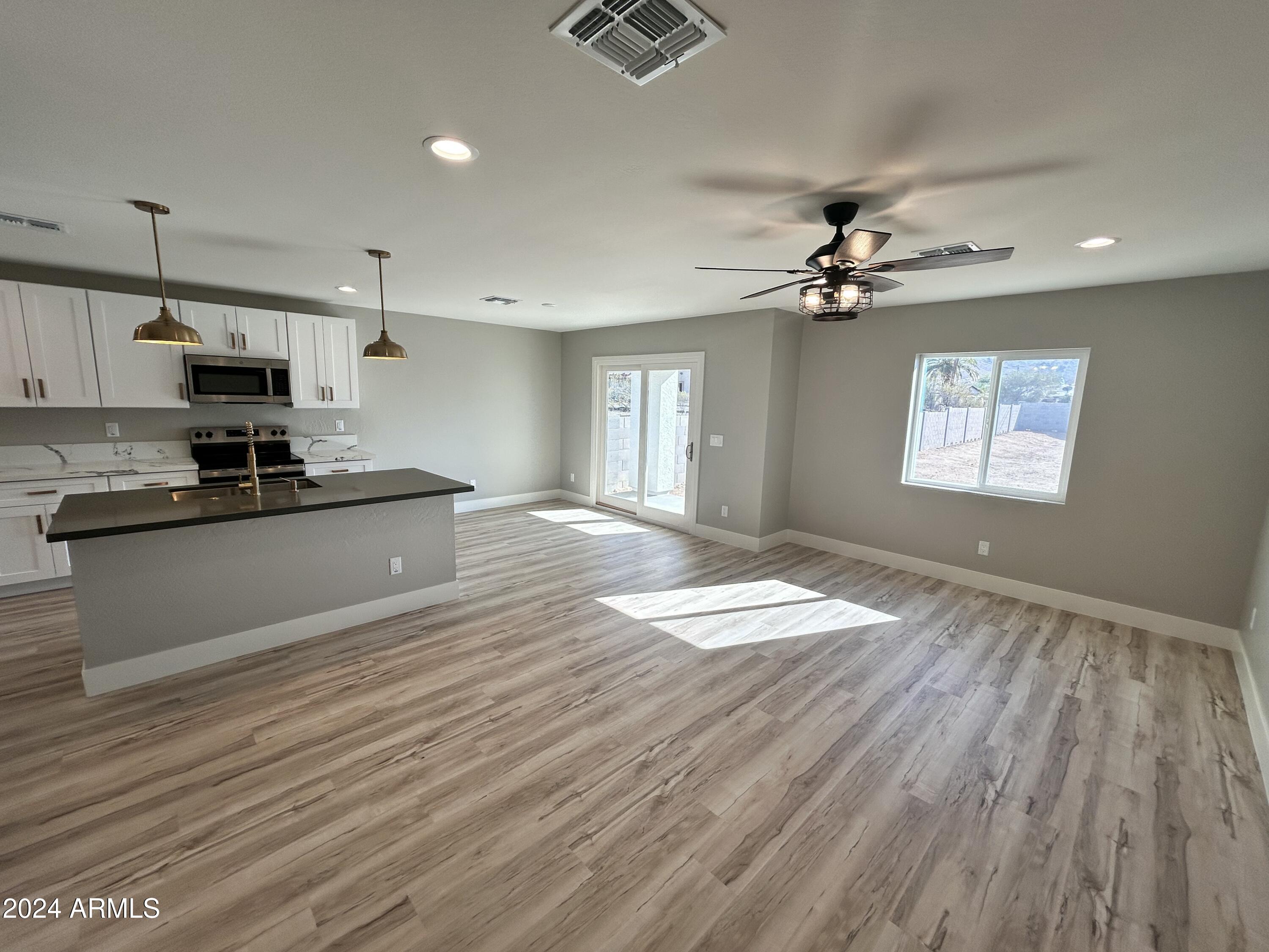 825 West Dobbins Road Phoenix, AZ 85041 - Photo 60 of 99 a kitchen with kitchen island granite countertop a sink cabinets stainless steel appliances and a counter top space